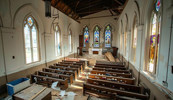 Damaged church interior with broken pews and debris