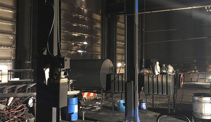 Professionals inspecting smoke damage in a factory