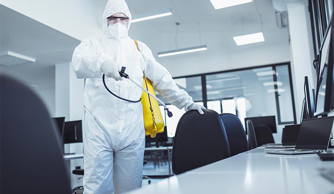 A professional disinfecting an office room