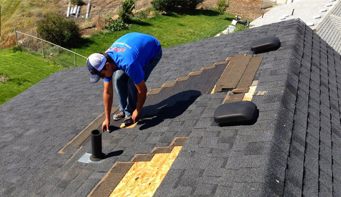 Professional repairing damaged shingles roof