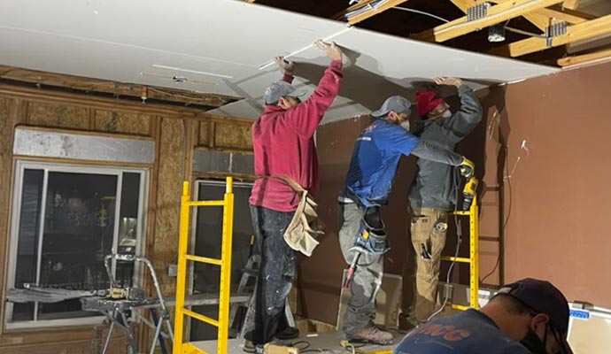 Professional team installing new ceiling on residential house