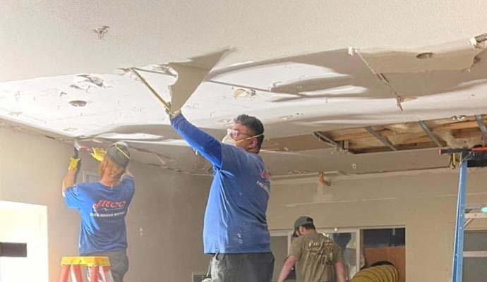 Professional team removing damaged ceiling for reconstruction service
