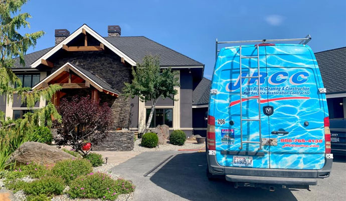 A blue Just Right Cleaning and Construction van in-front of a home