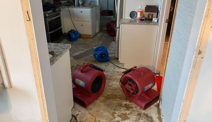 Extracting water from damaged floor with equipment