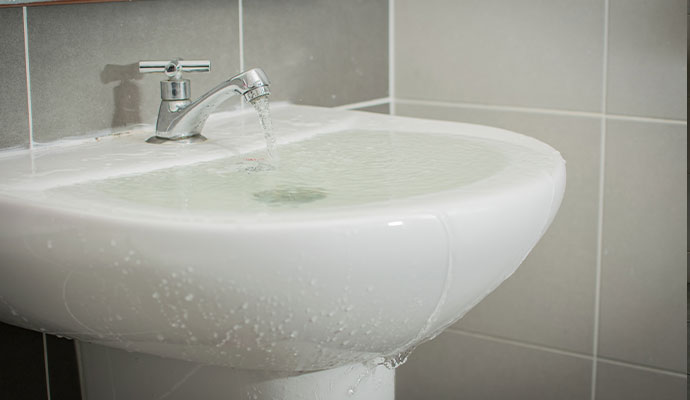 Bathroom sink overflowed by water